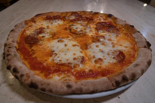 a cheese pizza sitting on a plate on a table at Hotel Tre Monti in Popoli