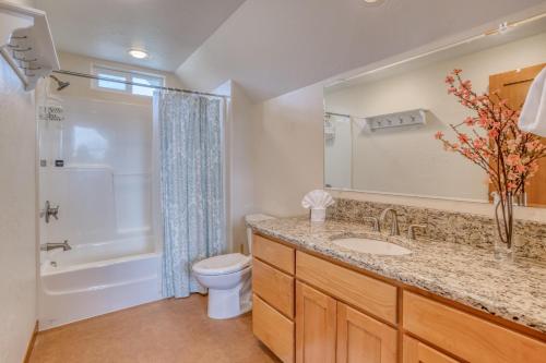 a bathroom with a sink and a toilet and a shower at Netarts Coastal Retreat - Meredith Lodging in Tillamook