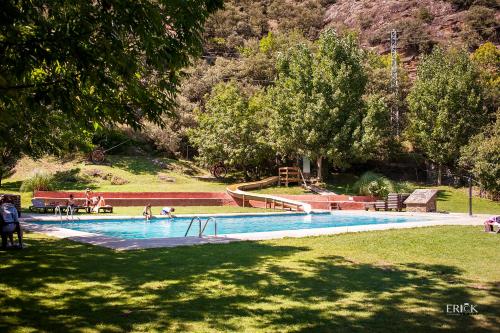 una piscina en un parque con gente jugando en ella en Camping Bungalows La Borda del Pubill, en Ribera de Cardós
