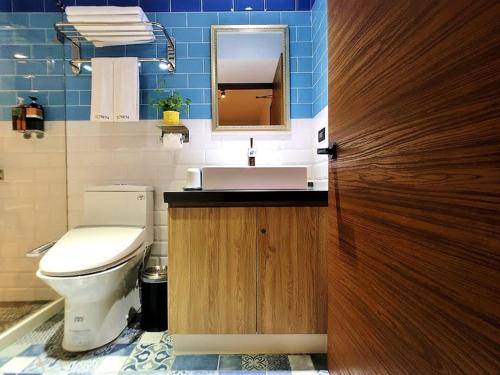 a bathroom with a toilet and a sink and a mirror at Journey Town Inn in Taipei