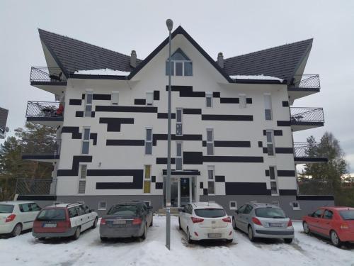 a building with cars parked in front of it at Crni bor in Divčibare