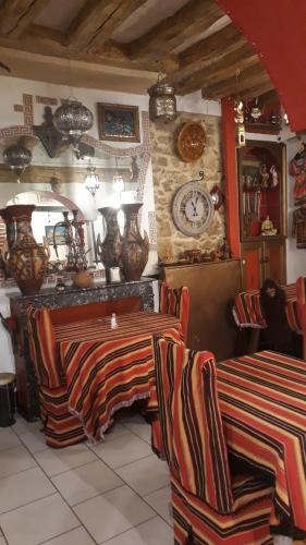 a room with two tables and a clock on the wall at Marie-Claire la grillade in Briare