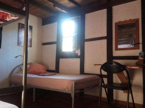 a bedroom with a bunk bed and a chair at Fundalucia Guesthouse in Quéntar