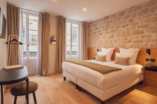 A bed or beds in a room at Tinah Paris, Champs Elysées