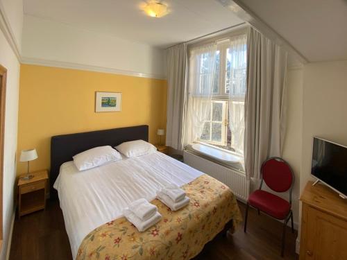 ein Schlafzimmer mit einem Bett mit Handtüchern darauf in der Unterkunft Landgoed Huize Glory in Bergen aan Zee