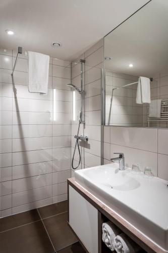 a white bathroom with a sink and a mirror at Villa Prinzhorn in Diepholz