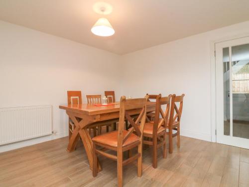 a dining room with a wooden table and chairs at The Outlook in Taunton