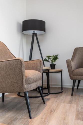 a group of three chairs and a lamp in a room at Hotel de Rousch - 4 sterren Superieur in Heerlen
