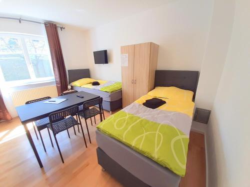 ein Schlafzimmer mit einem Bett und einem Tisch sowie ein Esszimmer in der Unterkunft Apartments SteelCity in Linz