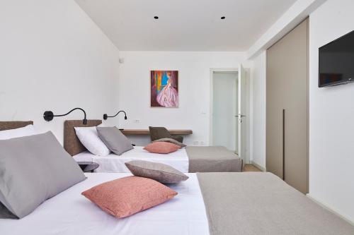 a bedroom with three beds and a flat screen tv at Villa Ansi by Villas Holiday in Višnjan