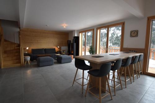Il dispose d'une cuisine et d'un salon avec une table et des chaises en bois. dans l'établissement VAUJANYLOCATIONS - Le Chalet d Antoine et Mary, à Vaujany