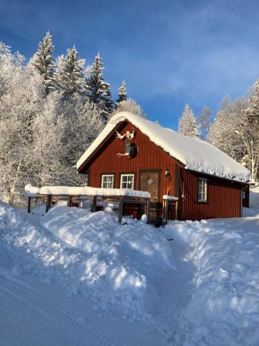 a small red cabin with snow on the roof at Vålågårdens Värdshus och Camping AB in Vålådalen