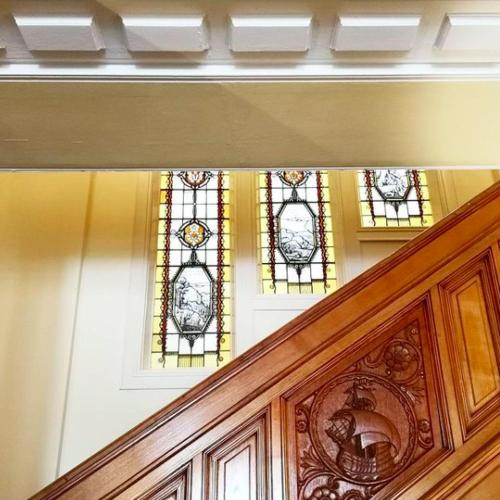 two stained glass windows on the top of a staircase at Landgoed Huize Glory in Bergen aan Zee