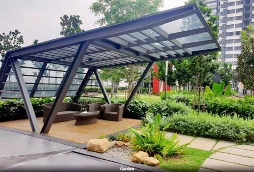 a patio with a blue canopy in a garden at The Lake-ville KL Jalan Kuching by M Platinum in Kuala Lumpur