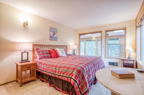 a bedroom with a bed and a table and two windows at Red Cedar Lane 60 - Meredith Lodging in Sunriver