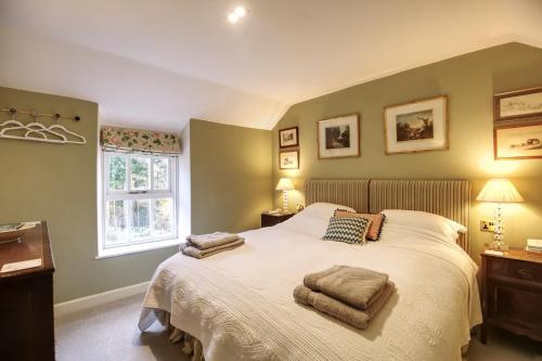 een slaapkamer met een bed met twee handdoeken erop bij Stunning 3-Bed House in a private hidden valley in Denbigh