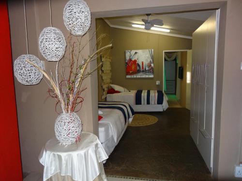 a bedroom with a bed and a table with a vase at Waterglen Guest Lodge in Rustenburg