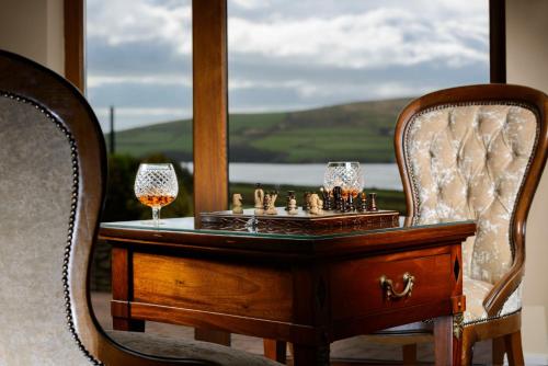 a wooden table with two wine glasses and a chess board on it at Greenmount House in Dingle