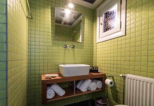 a green tiled bathroom with a sink and a mirror at DIMITRIOS in Skiros