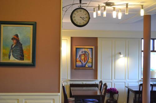 a clock on the wall above a dining room at Hotel Plaza in Lommel