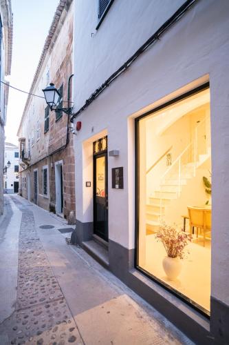 a building with a window with a table in it at 971 Hotel Con Encanto in Ciutadella
