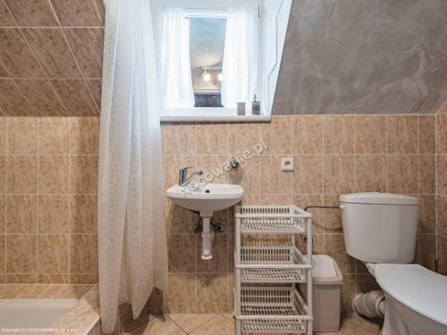 łazienka z umywalką, toaletą i oknem w obiekcie Penzion u Laca w Zuberzcu