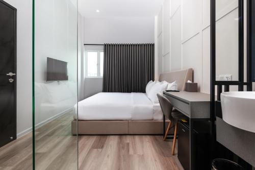 a bedroom with a bed and a desk and a sink at Wesley Hotel in Bukit Mertajam