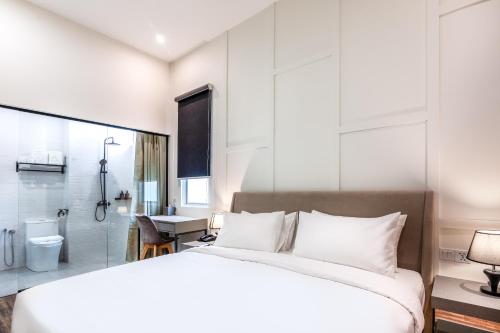 a bedroom with a large white bed and a bathroom at Wesley Hotel in Bukit Mertajam