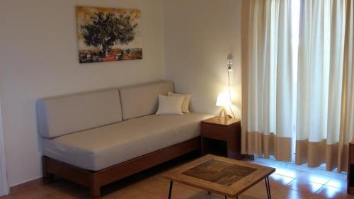 ein Wohnzimmer mit einem Sofa und einem Tisch in der Unterkunft Kallicrates Village in Frangokástellon