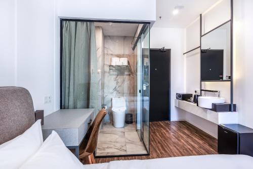 a bathroom with a shower and a toilet and a sink at Wesley Hotel in Bukit Mertajam
