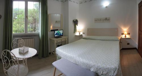 a bedroom with a bed and a tv and a window at Casa Margherita Affittacamere B&B in Follonica