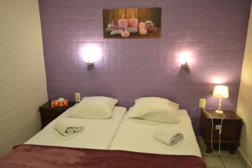 a small bedroom with two beds and two lamps at Hotel Plaza in Lommel