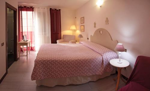フォッローニカにあるCasa Margherita Affittacamere B&Bのベッドルーム1室(ピンクのベッドカバー付きの大型ベッド1台付)