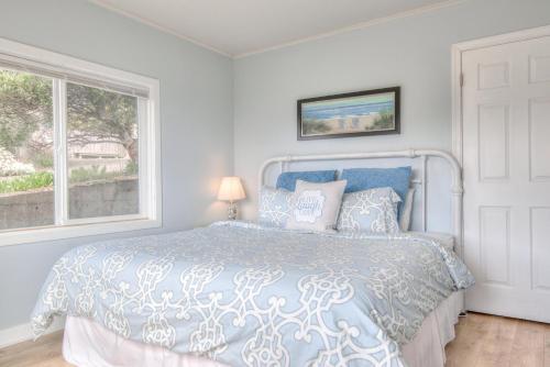 a bedroom with a blue bed with a window at Ohana Shores in Lincoln City