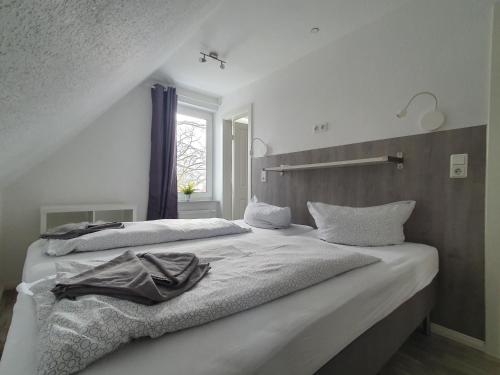 Krabbenkieker في نوردين: غرفة نوم بيضاء بسريرين ونافذة