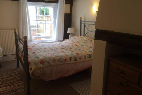 a small bed in a bedroom with a window at Cathedral View Cottage, Canterbury in Kent