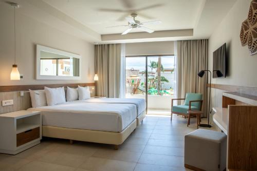 a hotel room with a bed and a balcony at Bahia Principe Grand Tulum - All Inclusive in Akumal