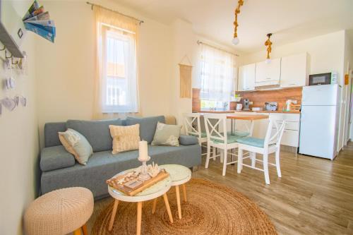a living room with a blue couch and a kitchen at OLEA Apartments Vir in Vir