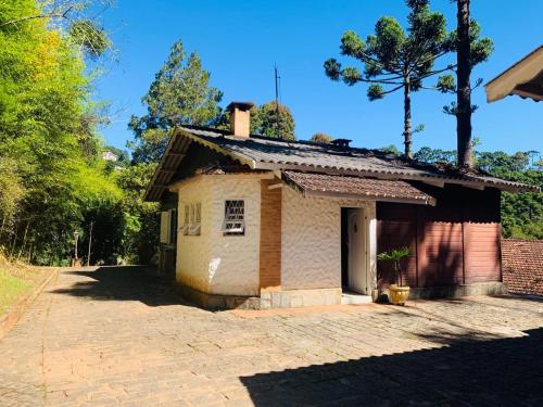 a small house with a brick driveway at Chalé Terrazza in Campos do Jordão