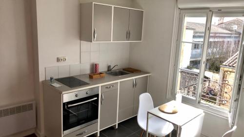 une cuisine avec un évier, une table et une fenêtre dans l'établissement Le printemps de mélusine, à Niort