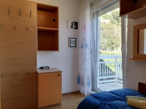 - une chambre avec un lit et une grande fenêtre dans l'établissement Apartment Kika ***, à Pučišća