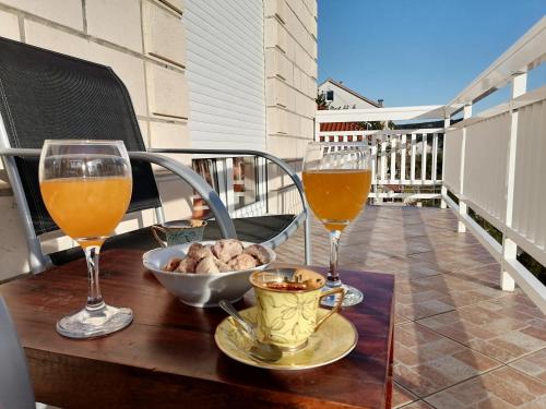 - deux verres de vin et un bol de nourriture sur une table dans l'établissement Apartment Kika ***, à Pučišća