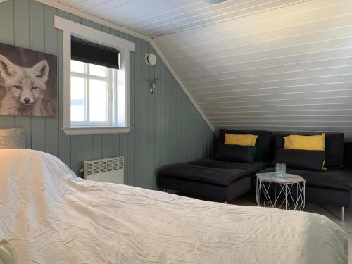 a bedroom with a bed and a couch and a window at Lemonsjøen-Jotunheimen-Besseggen in Stuttgongfossen