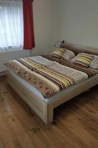 Apartmán u sjezdovky Filipovice في Filipovice: وجود سرير على أرضية خشبية في غرفة النوم