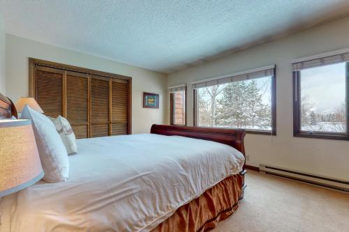 a bedroom with a large bed and two windows at Darwin E in Jackson