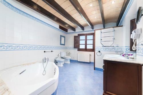 een grote badkamer met een bad en 2 toiletten bij New Can Furios Hotel by Can Calco Hotels in Selva