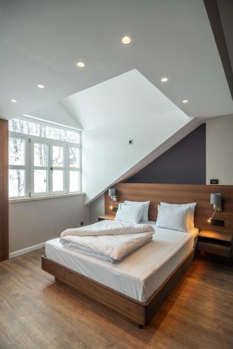 a bedroom with a large bed with a large window at Vila Emilia in Vrnjačka Banja