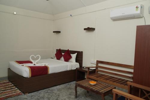 um quarto com uma cama e um banco em Havelock Farms Resort em Ilha Havelock