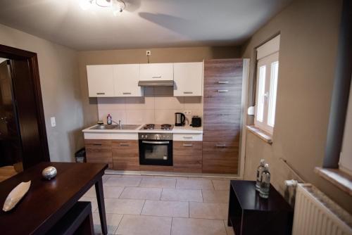 a kitchen with white cabinets and a table in it at main Appartments Frankfurt Airport in Kelsterbach