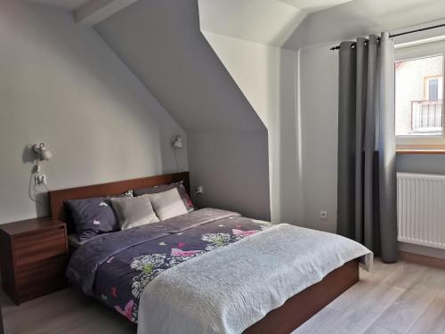 a bedroom with a bed and a window at Apartament Z Widokiem in Polanica-Zdrój